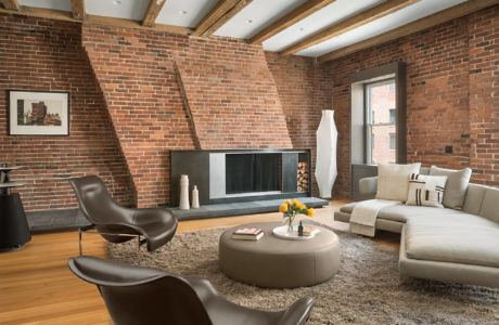 Modern living room with brick walls, fireplace, and contemporary furniture.