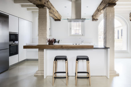 Minimalist kitchen with sleek cabinetry and exposed stone columns.