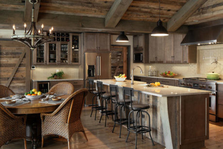 Rustic kitchen with wooden beams, farmhouse table, and breakfast bar.