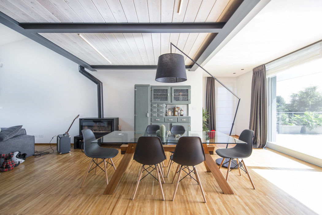 Contemporary dining area with hardwood floors and a large pendant light.