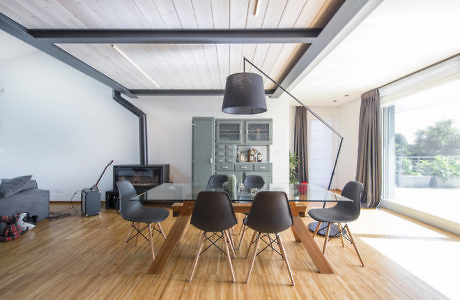 Contemporary dining area with hardwood floors and a large pendant light.