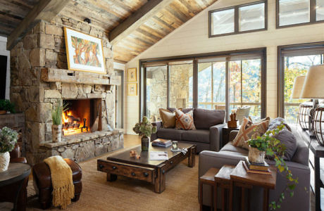 Cozy living room with a stone fireplace and wooden ceiling.