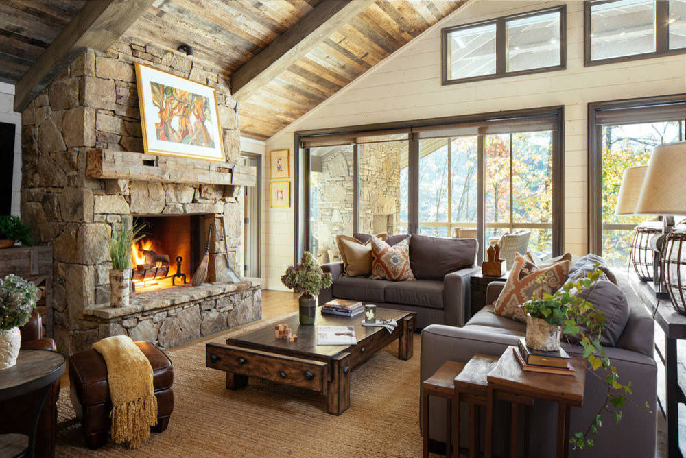 Cozy living room with a stone fireplace and wooden ceiling.