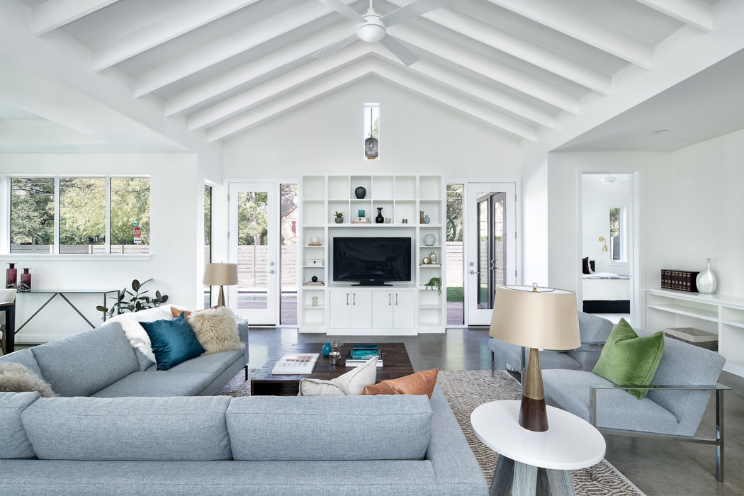 Bright modern living room with vaulted ceiling and white decor.