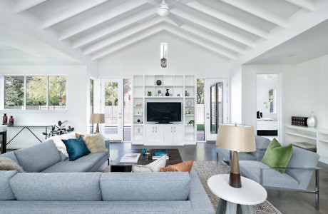 Bright modern living room with vaulted ceiling and white decor.