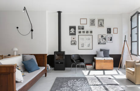 Modern living room with white walls, fireplace, and assorted furniture.