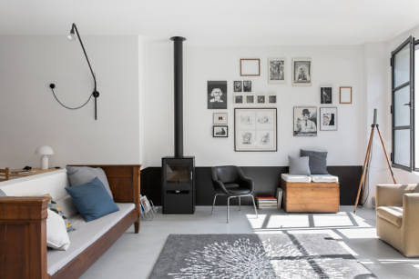 Modern living room with white walls, fireplace, and assorted furniture.