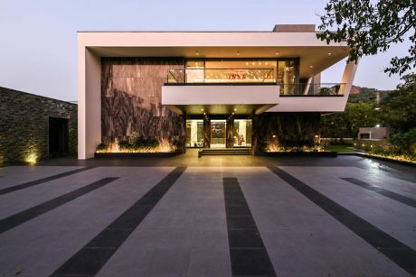 Modern two-story house with large windows at dusk.