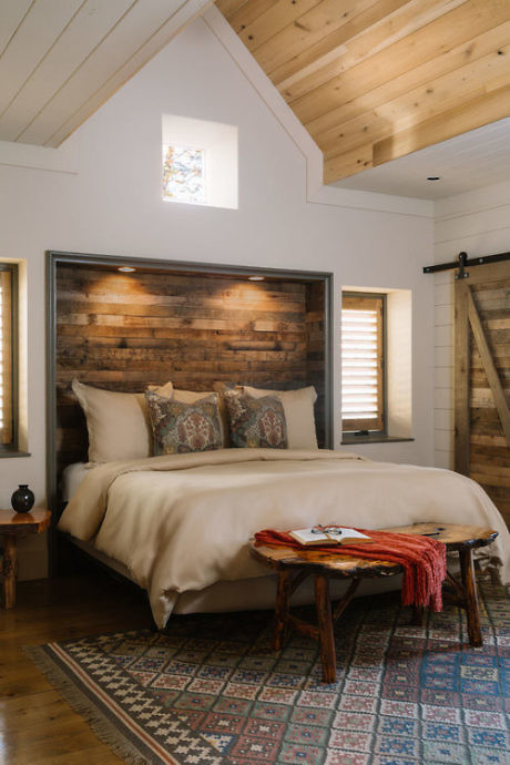 Cozy bedroom with rustic wood headboard and vaulted ceiling.