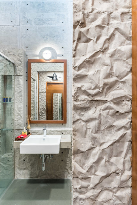 Contemporary bathroom with textured walls and glass shower enclosure.
