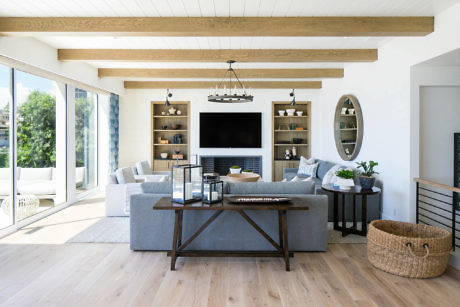 Bright living room with a sofa, coffee table, fireplace, and large windows.