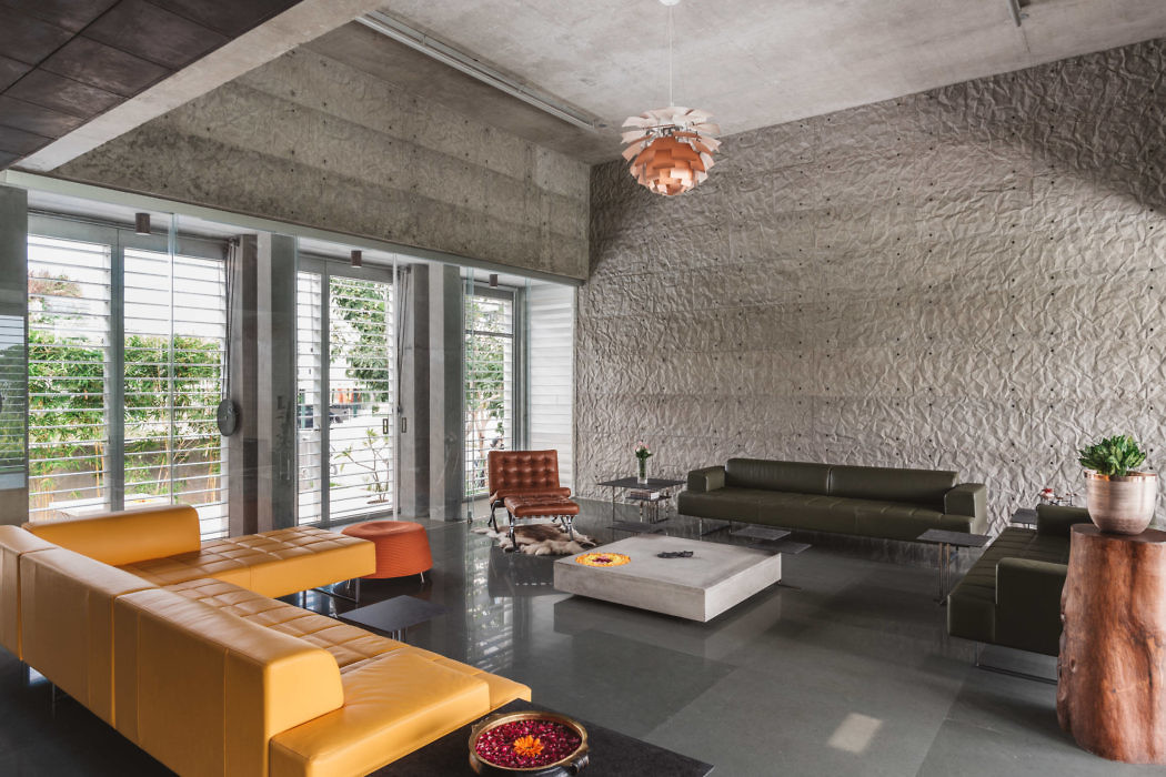 Modern living room with textured walls, concrete ceiling, and colorful furniture.