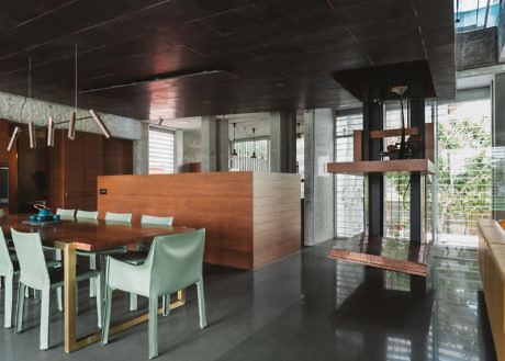 Contemporary dining area with sleek wood details and hanging shelving unit.