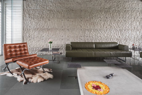 Modern living room with textured wall, leather furniture, and minimal decor.