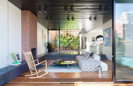 Contemporary living space with a rocking chair, sofa, and expansive glass wall.