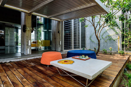 Contemporary outdoor lounge with colorful seats and wooden decking.