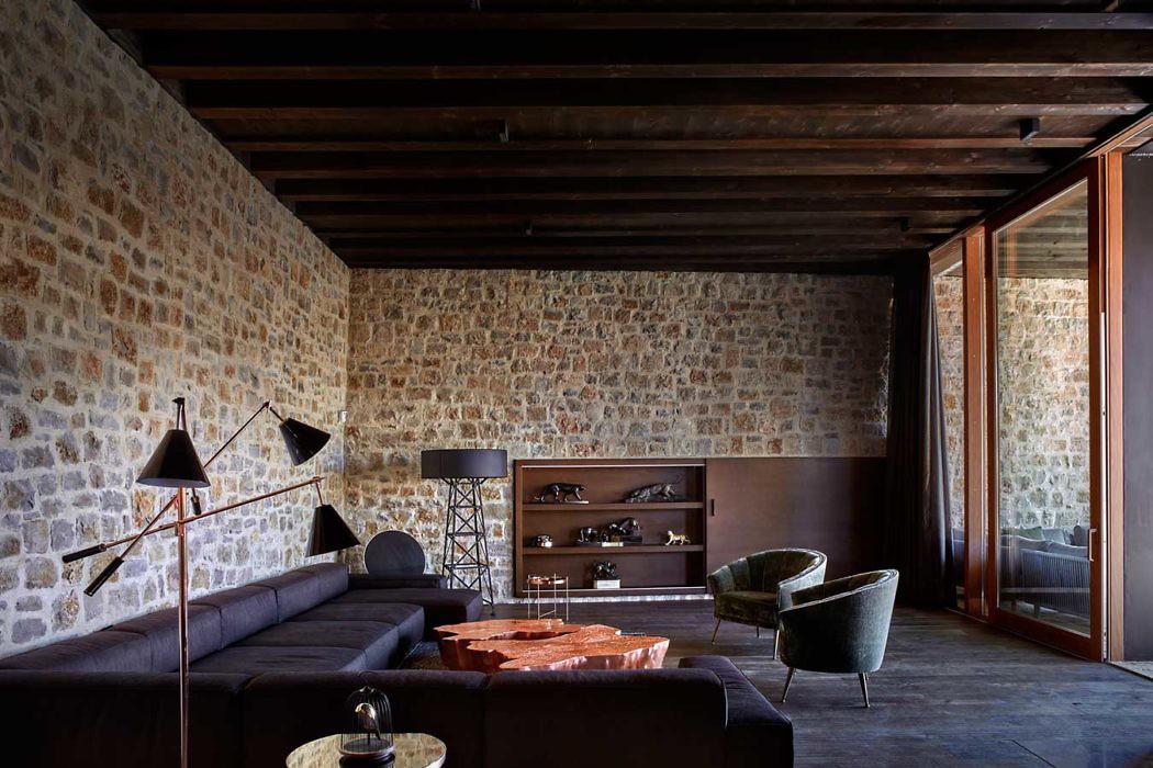 Contemporary room with stone walls and dark wood beams.