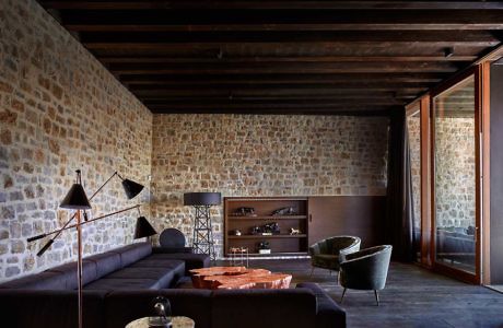 Contemporary room with stone walls and dark wood beams.