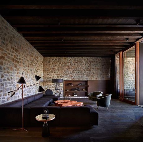 Contemporary room with stone walls and dark wood beams.