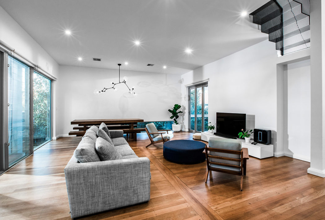 Contemporary living room with hardwood floors and minimalist decor.