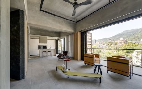 Spacious industrial-style living room with panoramic windows and minimalist furniture.