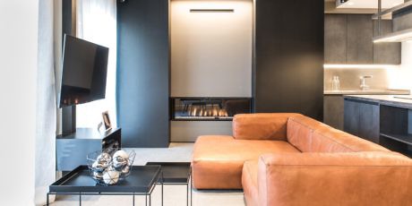 Modern living room with sleek furniture and a mounted TV.