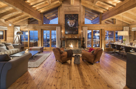 Cozy mountain cabin living room with a fireplace and wood beam ceiling.