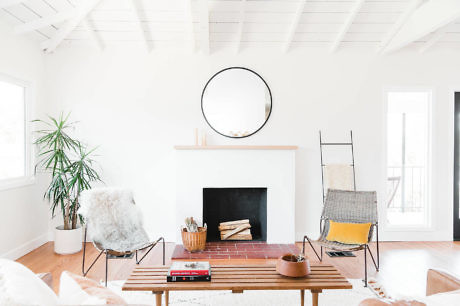 Bright minimalist living room with white walls and fireplace.