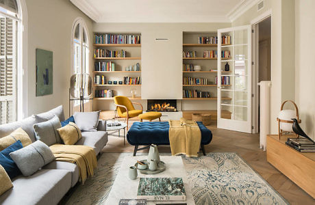 Elegant living space with book-lined walls and colorful furniture.