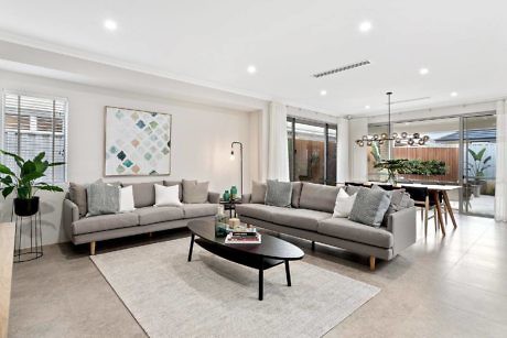 Modern living room with sectional sofa, dining area in the background.