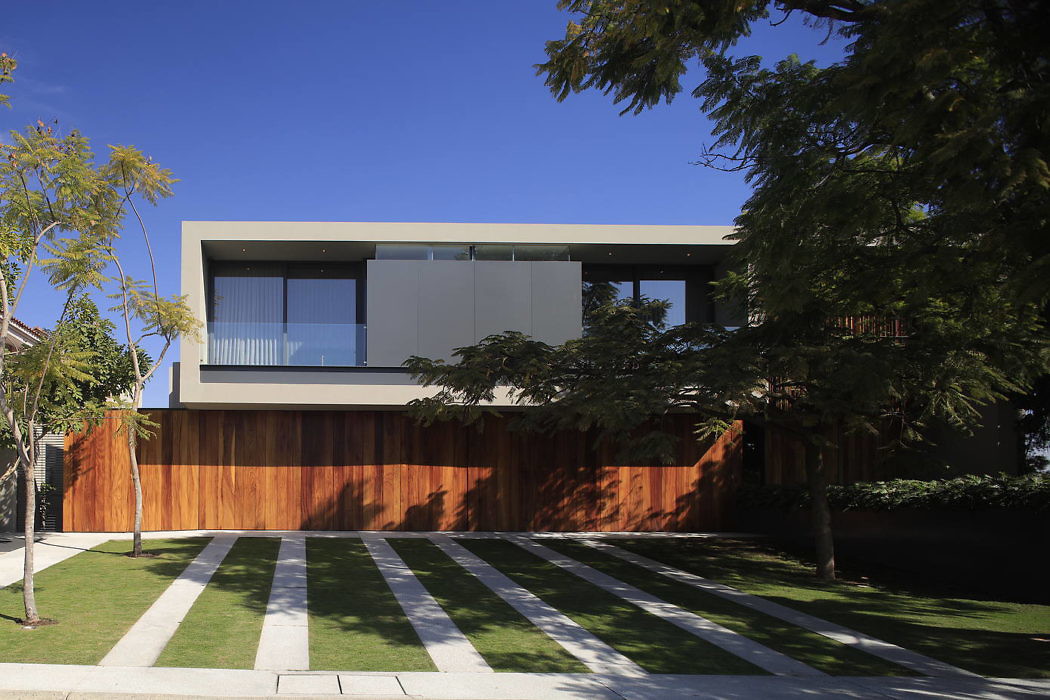 Modern house with a wooden facade and landscaped lawn.