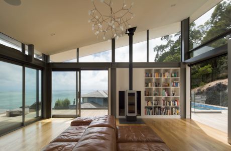 Sleek living space with floor-to-ceiling windows overlooking the sea.