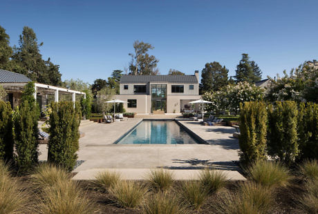 Contemporary house with pool and manicured garden.