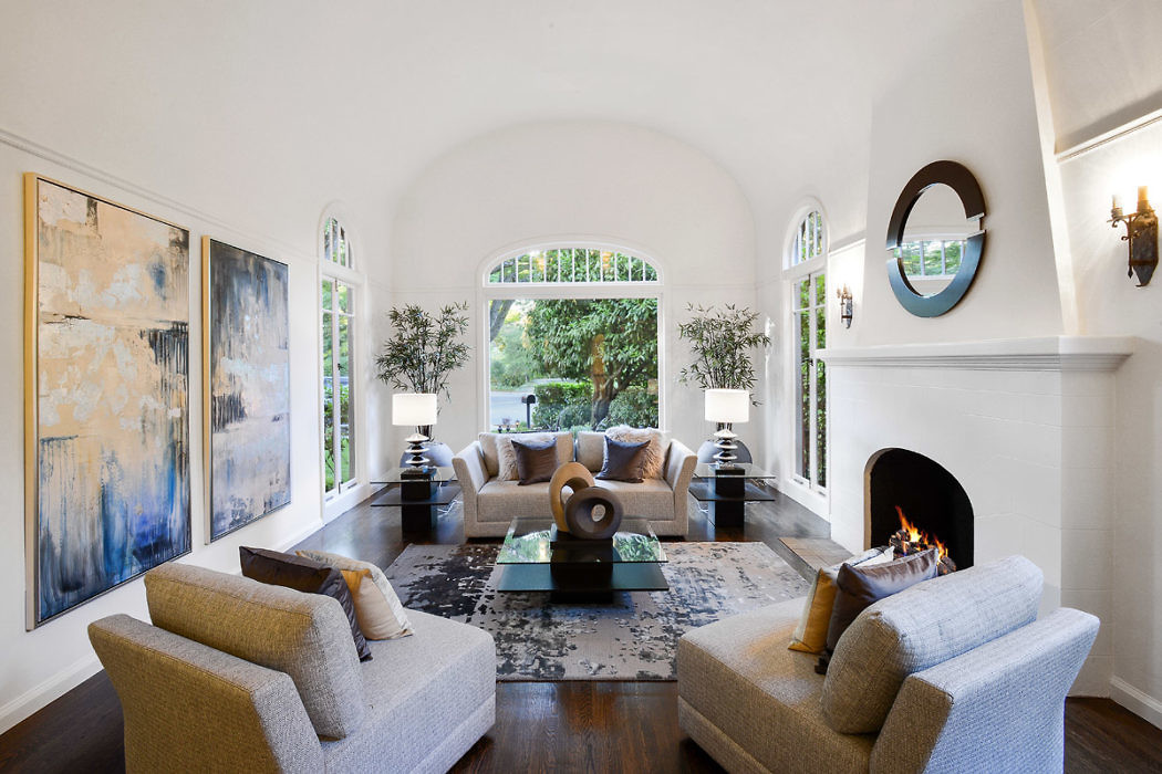 Elegant living room with arched windows, a fireplace, and contemporary furniture.