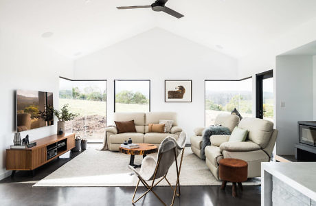 Bright living room with modern furniture and large windows.