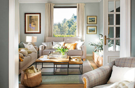 Elegant living room with neutral tones, plush sofa, and large window.