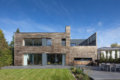 Modern two-story house with wooden facade and large windows.