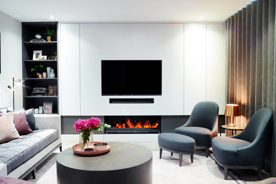 Sleek living room with wall-mounted TV above a fireplace, plush seating,