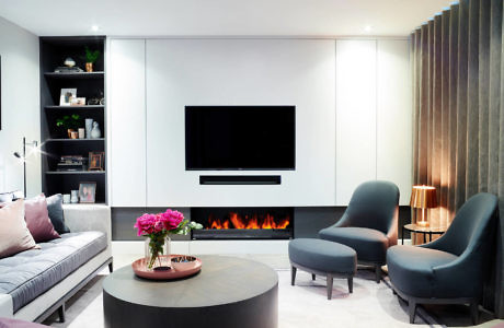 Sleek living room with wall-mounted TV above a fireplace, plush seating,