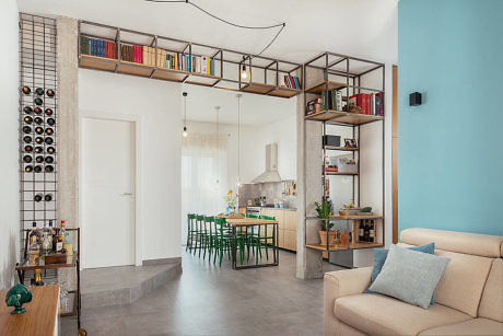 Modern living room connected to kitchen with shelving and wine rack.