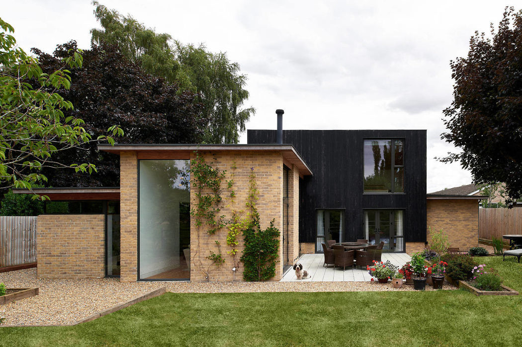 Contemporary home with contrasting brick and black cladding, large windows, and a