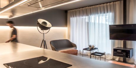 Sleek interior with indirect lighting, minimalist furniture, and a person walking by