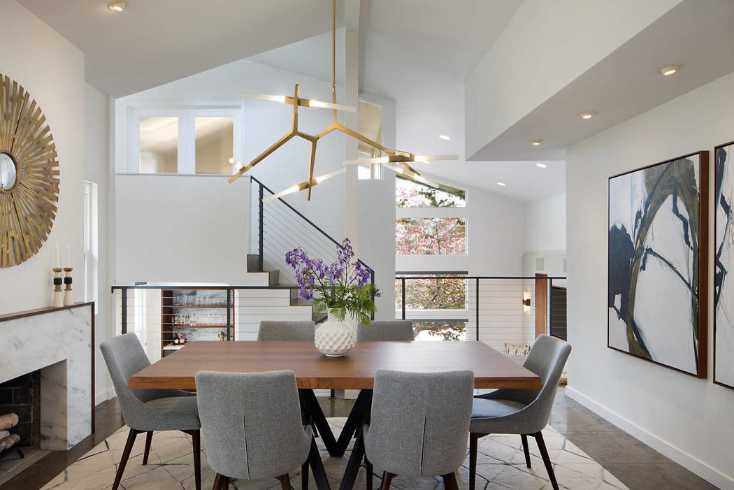 Contemporary dining room with geometric chandelier and art decor.