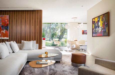 Modern living room with art, sectional sofa, and wooden paneling.