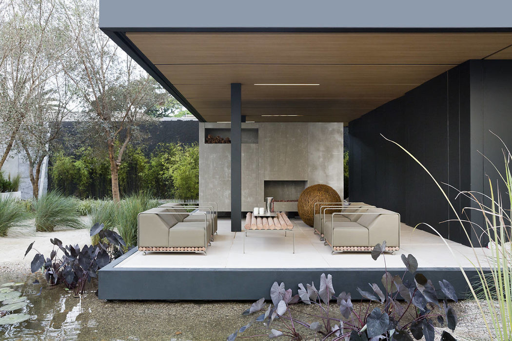 Contemporary outdoor patio with sleek furnishings and pond.