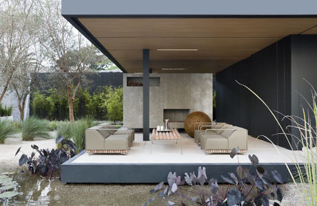 Contemporary outdoor patio with sleek furnishings and pond.