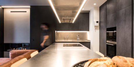 Modern kitchen interior with black cabinets and LED strip lighting.