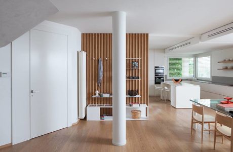 Modern interior with wooden floors, white walls, and a slatted partition.