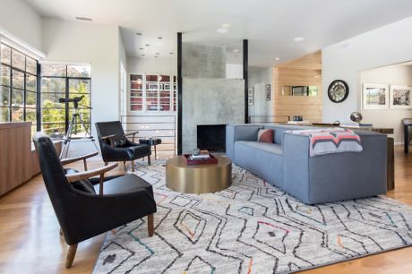 Modern living room with stylish furniture and a central fireplace.