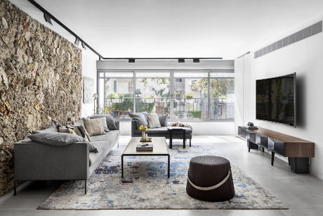 Contemporary living room blending natural stone wall with sleek furniture.